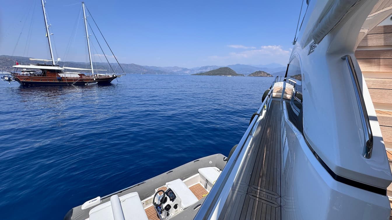 A Princess Y78 motor yacht moored stern-to-shore in a sheltered pine-fringed cove on Turkey's Lycian Coast near Göcek — a private Blue Cruise chapter by Throne Voyages.